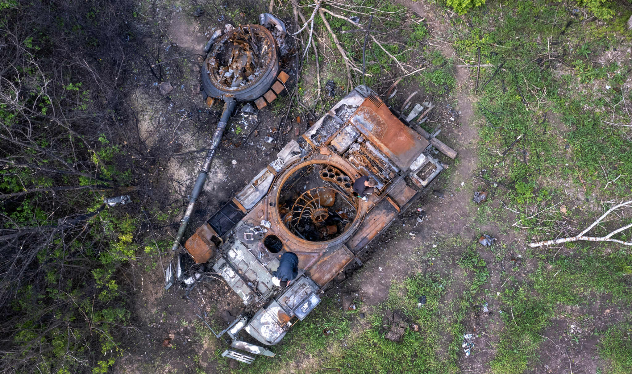 Ukrainians strip a Russian tank near Kharkiv on 16 May 2022. (Photo: John Moore / Getty)