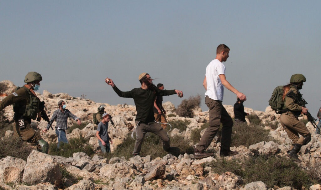 Israeli settlers hurl stones at Palestinians. (Photo: Nidal Eshtayeh / Xinhua via Alamy)