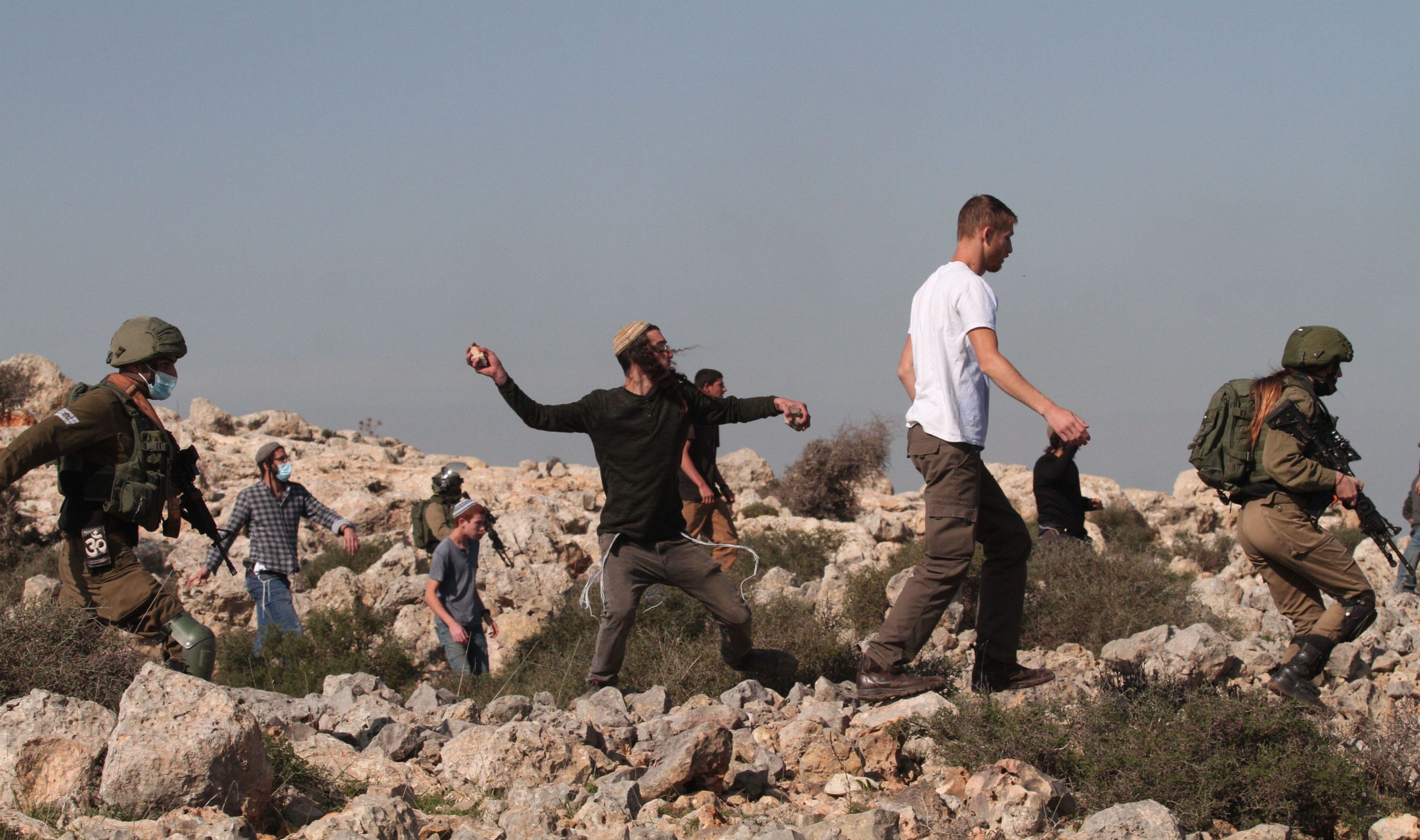 Israeli settlers hurl stones at Palestinians. (Photo: Nidal Eshtayeh / Xinhua via Alamy)