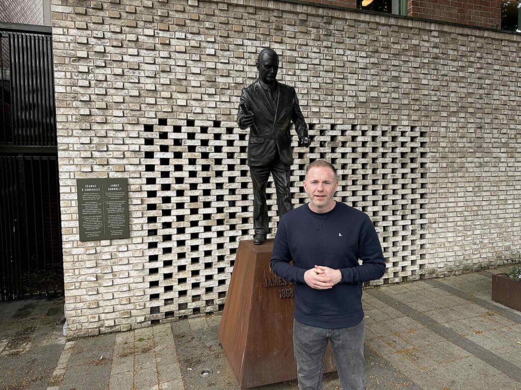 Chris Hazzard, Sinn Féin MP for South Down, in front of a statue of Irish independence leader James Connolly. (Photo: Matt Kennard/DCUK)