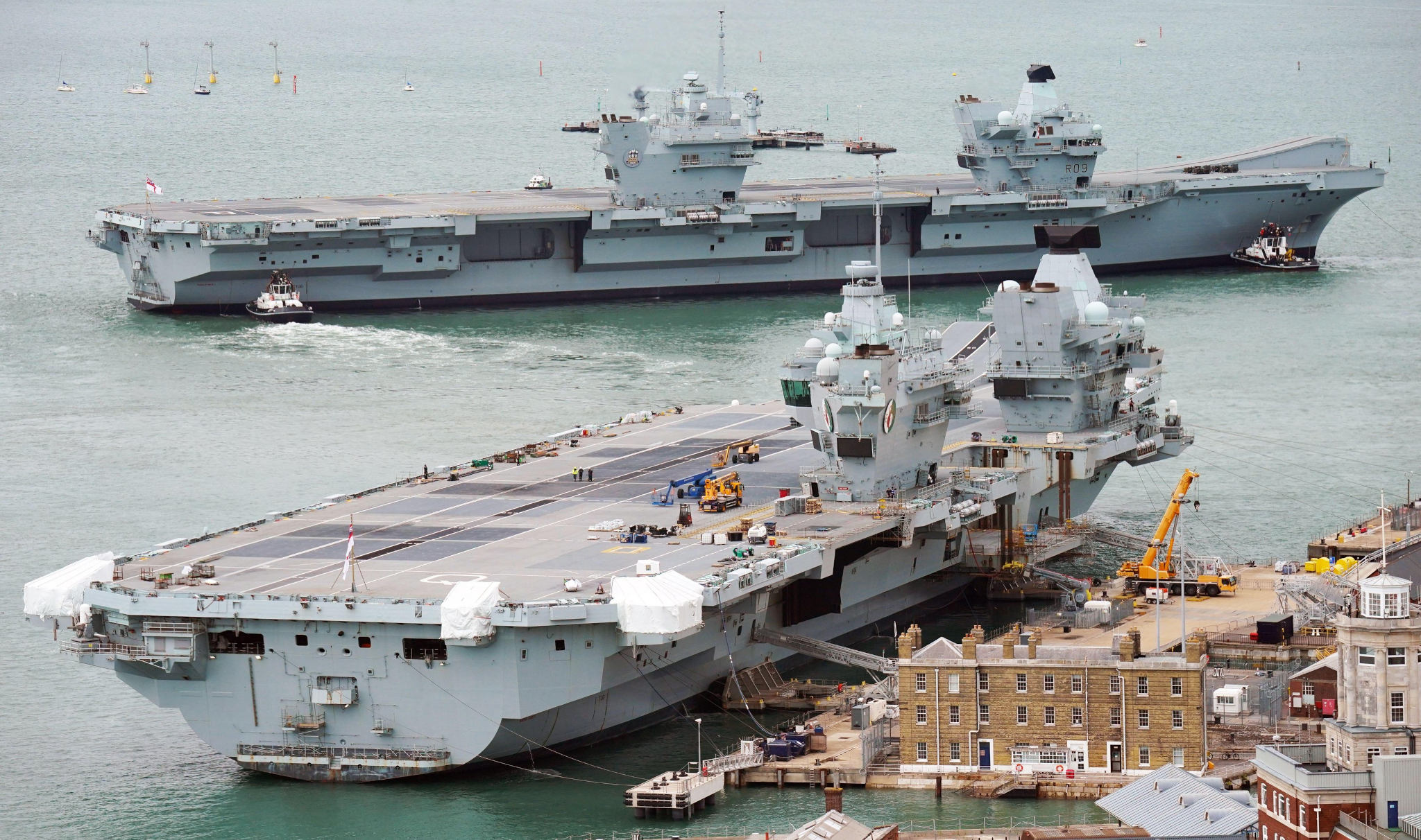 2RFM8FJ Aircraft carrier HMS Prince of Wales (back) berths alongside aircraft carrier HMS Queen Elizabeth as it arrives at Portsmouth Naval Base, following major repairs in Scotland after breaking down off the Isle of Wight nearly a year ago. Picture date: Friday August 4, 2023.