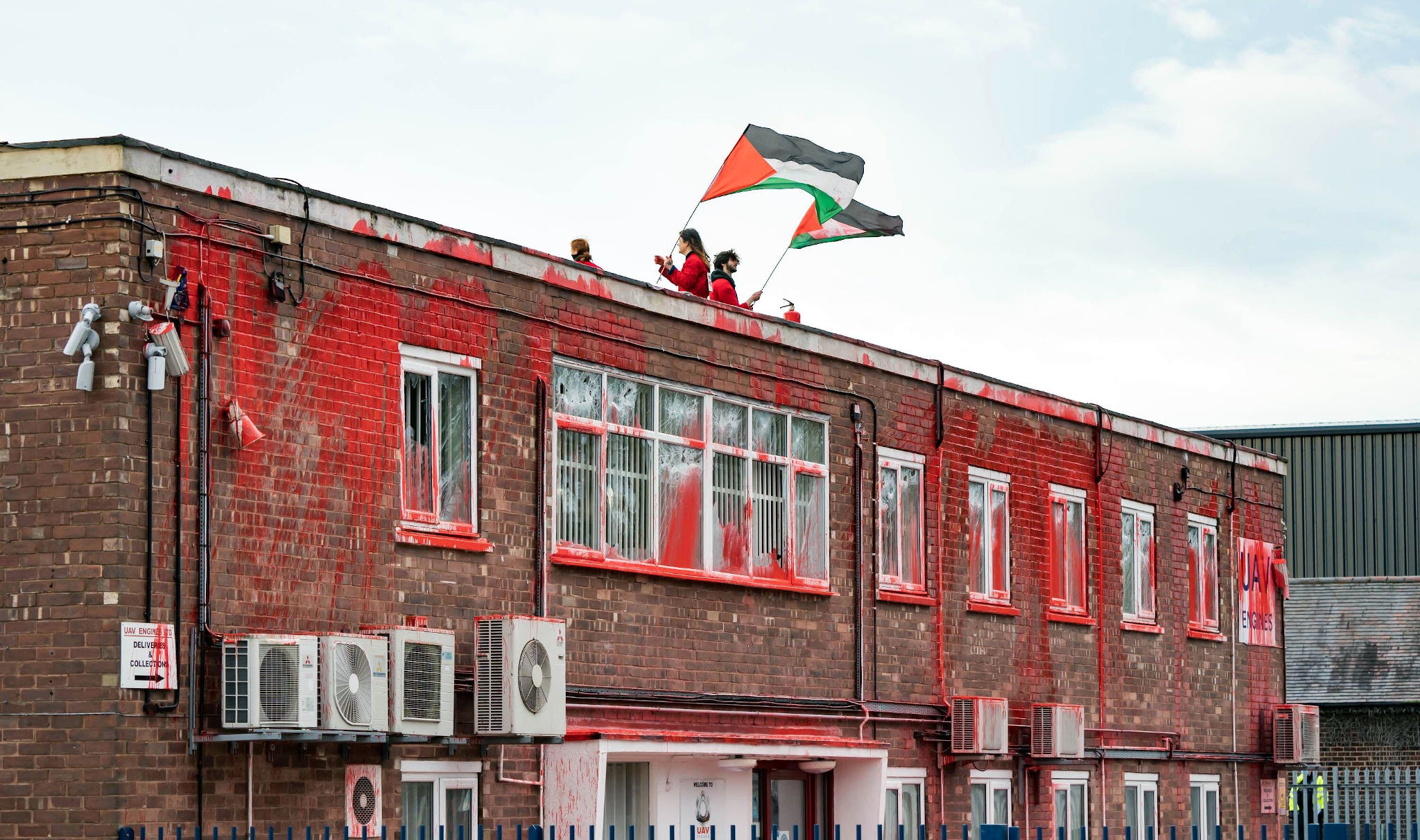 Shenstone, UK. 23 Feb, 2021. Activists from Palestine Action pour paint and smash windows as they protest on the roof of the UAV Engines Ltd factory in Shenstone, Lichfield in central-England on February 23, 2021. - Protestors stormed the site and climbed on the roof in the early hours of Tuesday morning. in Shenstone, UK. Credit: Vladimir Morozov/akxmedia. Credit: Vladimir Morozov/Alamy Live News