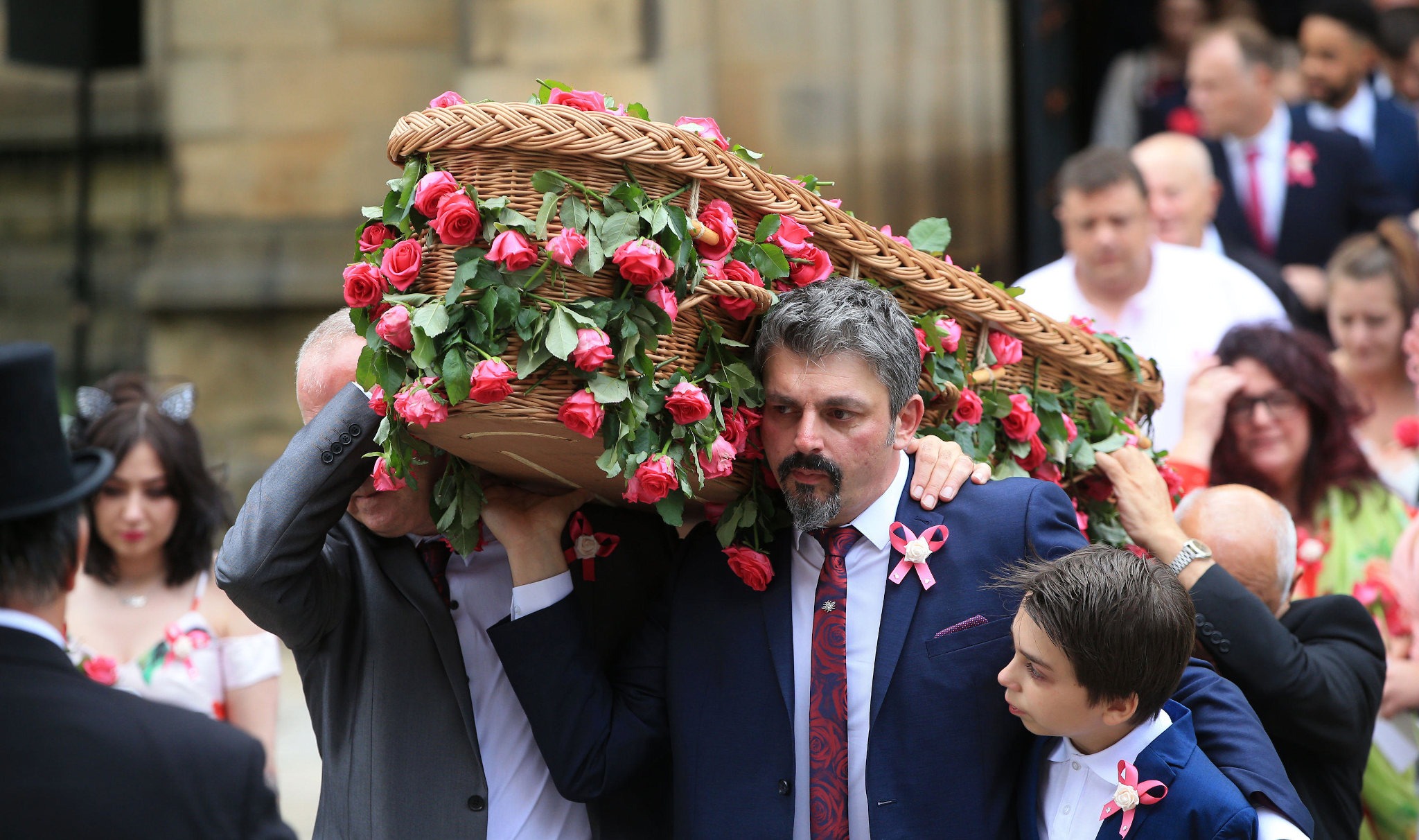 JM92FD Dad Andrew Roussos, 43, and brother Xander hold the coffin of Saffie Roussos, who died in the Manchester Arena bombing, as they leave Manchester Cathedral after her funeral service.