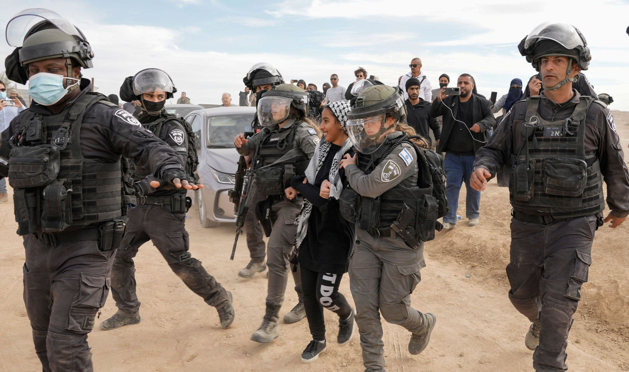 Israeli security forces detain a Bedouin youth during a protest against tree-planting by the Jewish National Fund on disputed land near beduin village of al-Atrash at the Negev desert, southern Israel, Wednesday, Jan. 12, 2022.
