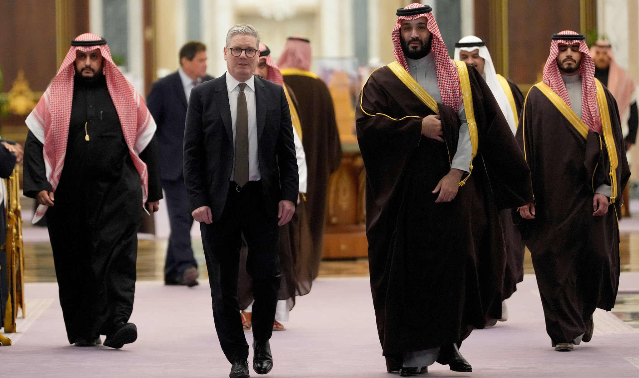 Keir Starmer and Mohammed bin Salman walking towards the camera with several other people in the background.