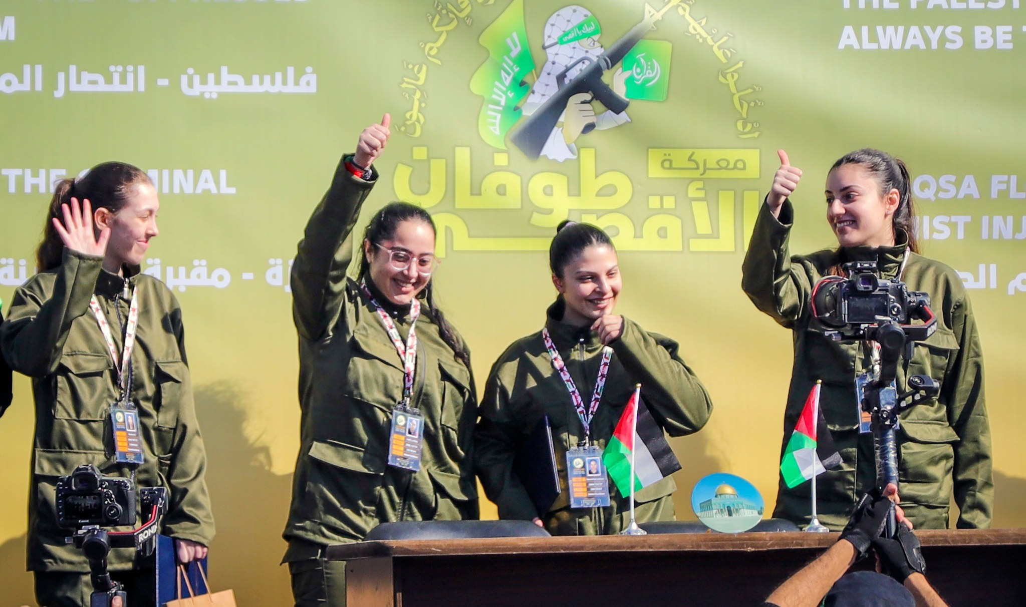 Israeli female soldier hostages salute a Palestinian crowd before being handed over to the Red Cross in Gaza City