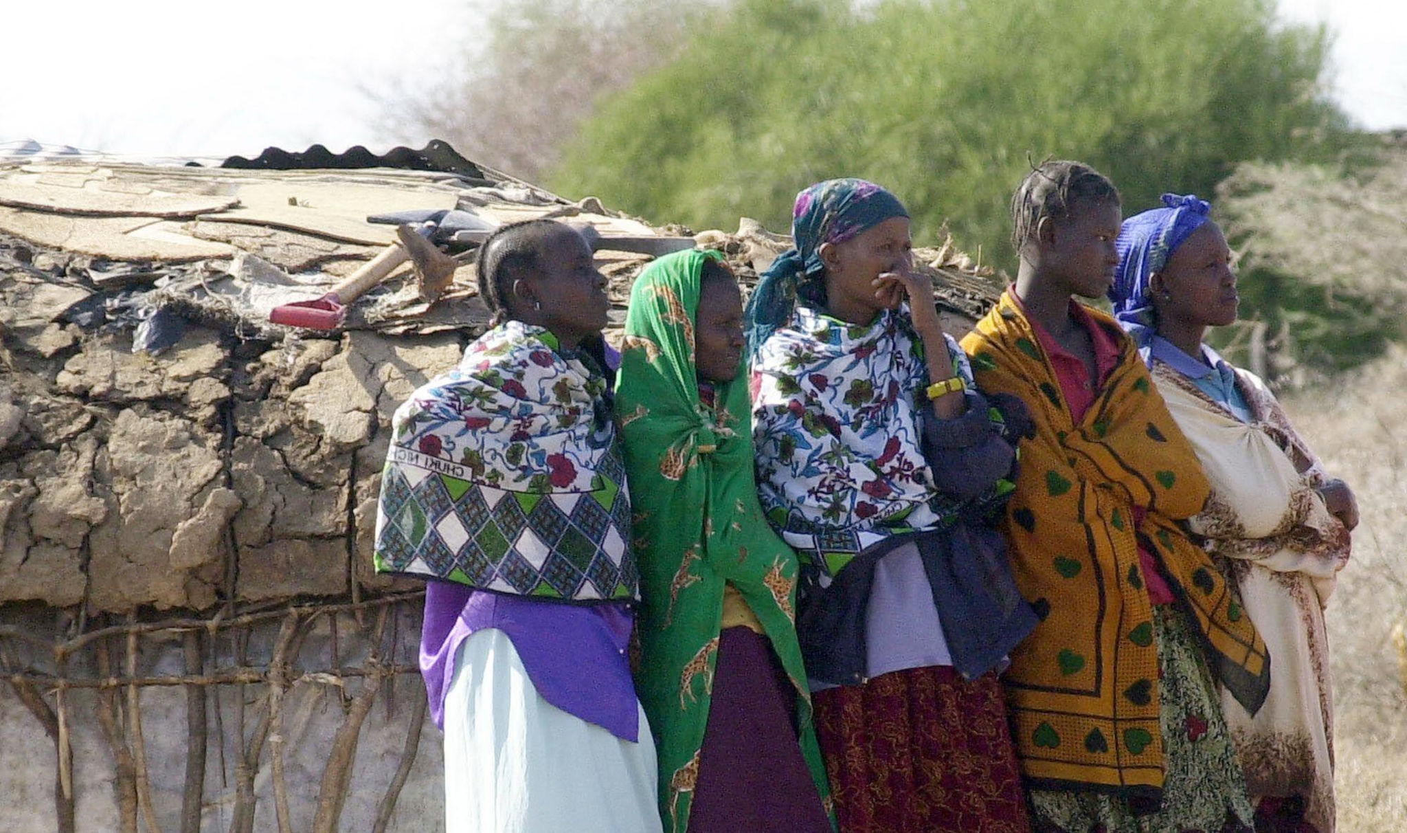 Villagers watch as forensic experts arrive at the site of an alleged rape and murder at Archer’s Post, 227 kilometers (141 miles) northeast of the capital Nairobi, Saturday Oct. 2, 2004. Kenyan and British investigators exhumed Saturday the remains of a w Women watch forensic experts arrive to exhume the body of Mantoi Lekoloi Kaunda. (Photo: Sayyid Azim / Alamy)