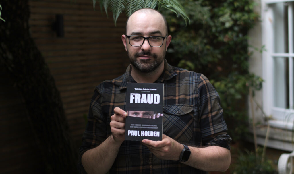 Author Paul Holden with his new book ‘The Fraud’. (Photo: Alex Morris / Declassified UK)