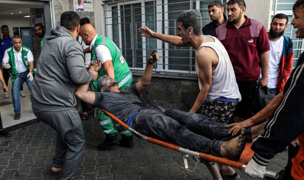 An injured Palestinian man carried into Al-Shifa Hospital in Gaza (Photo: Abed Khaled / Alamy)