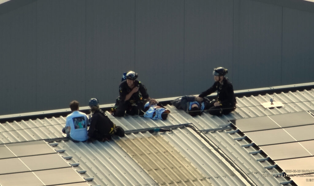 Three police officers detain three protesters on the roof of a factory